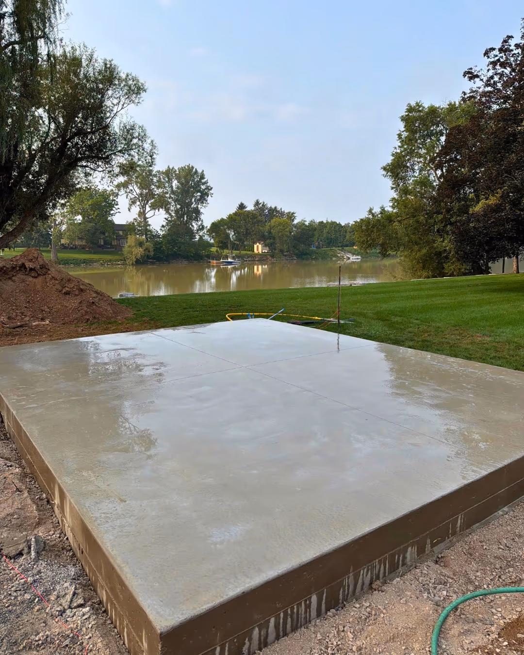 Freshly finished concrete slab in a backyard overlooking the water