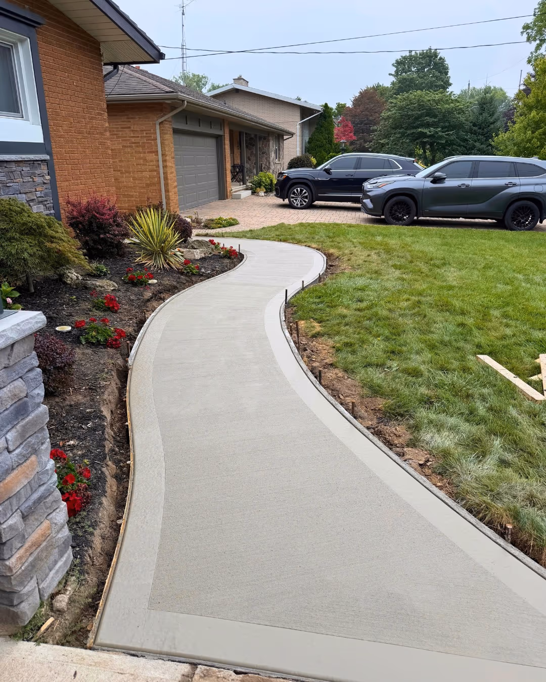Curved concrete sidewalk with a finished border through a front yard