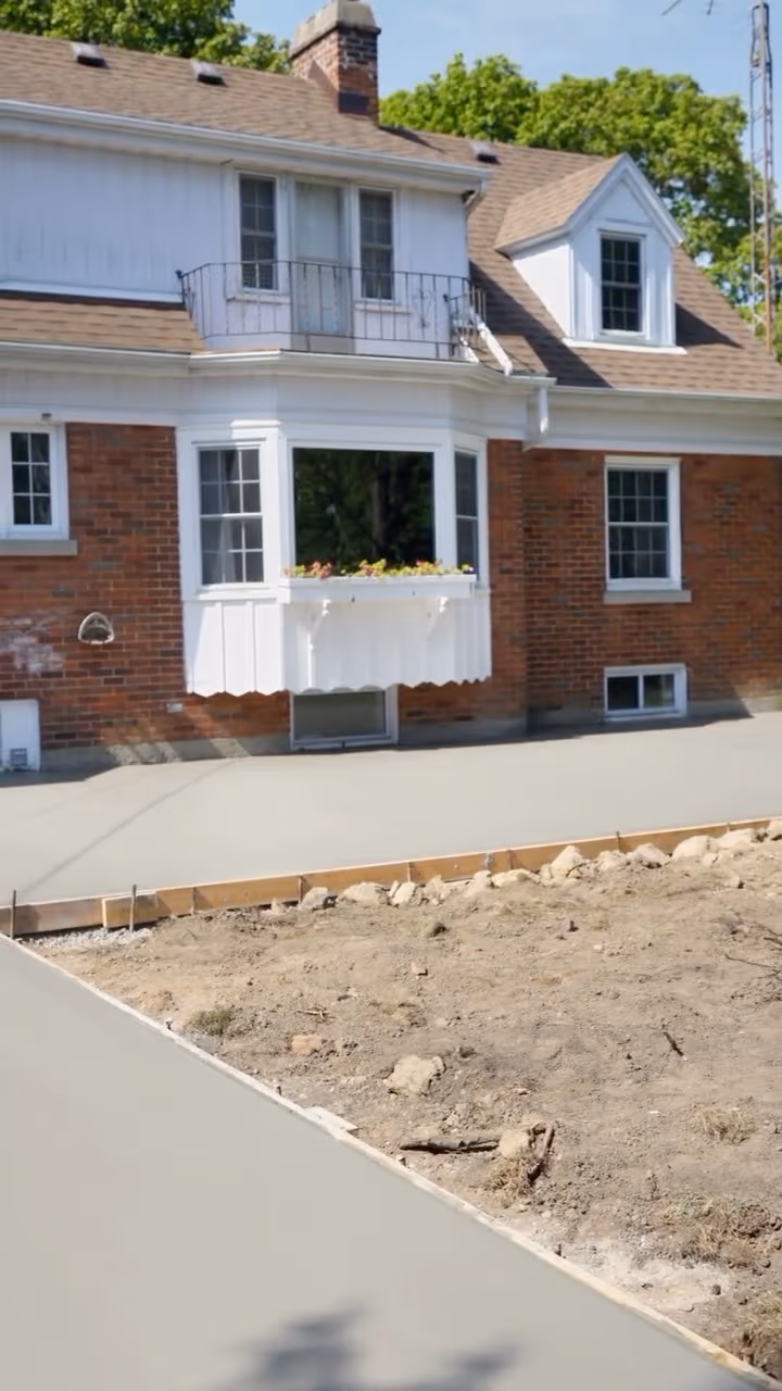 Smooth concrete patio and walkway poured beside a brick home